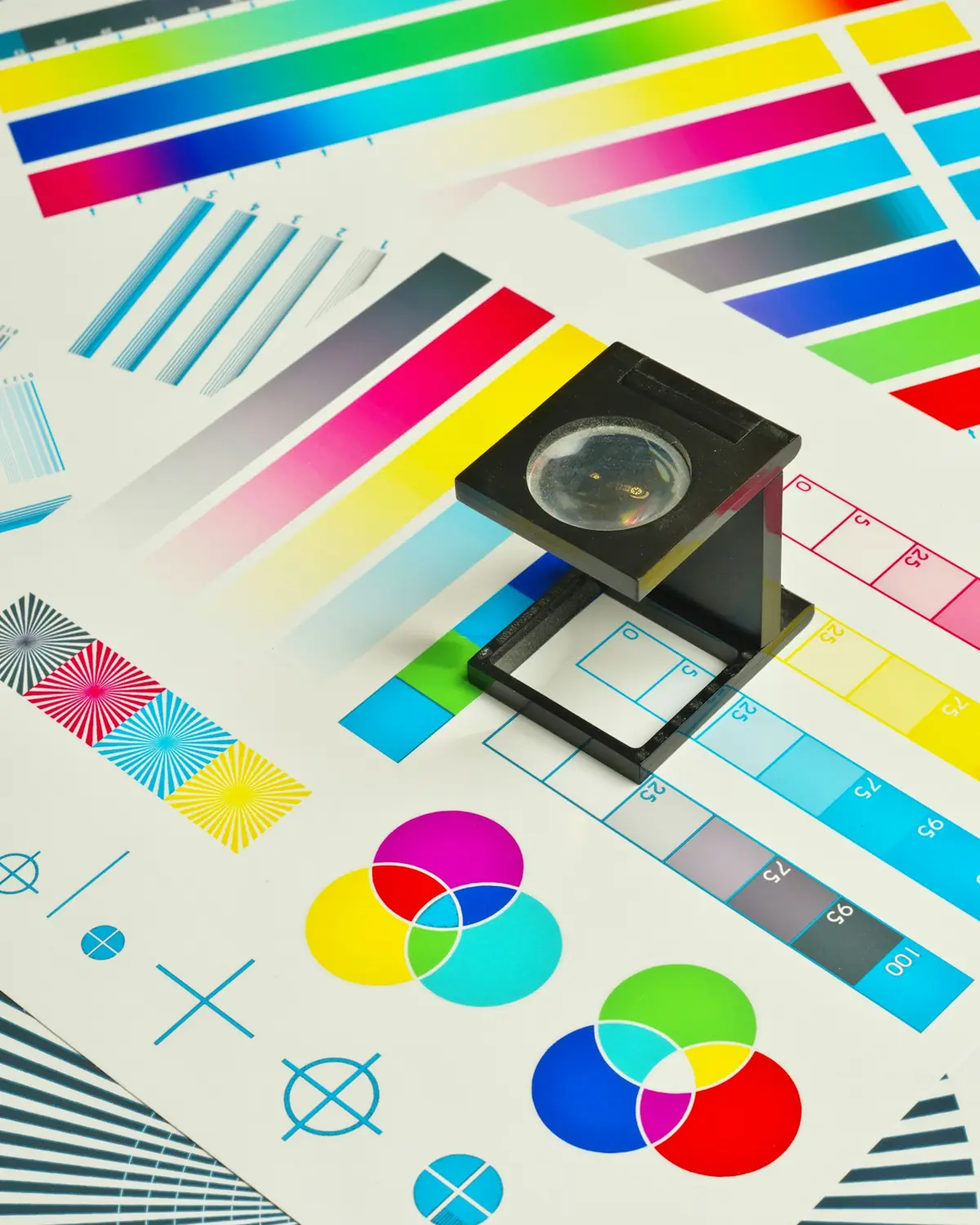 A linen tester resting on a printed CMYK calibration strip.